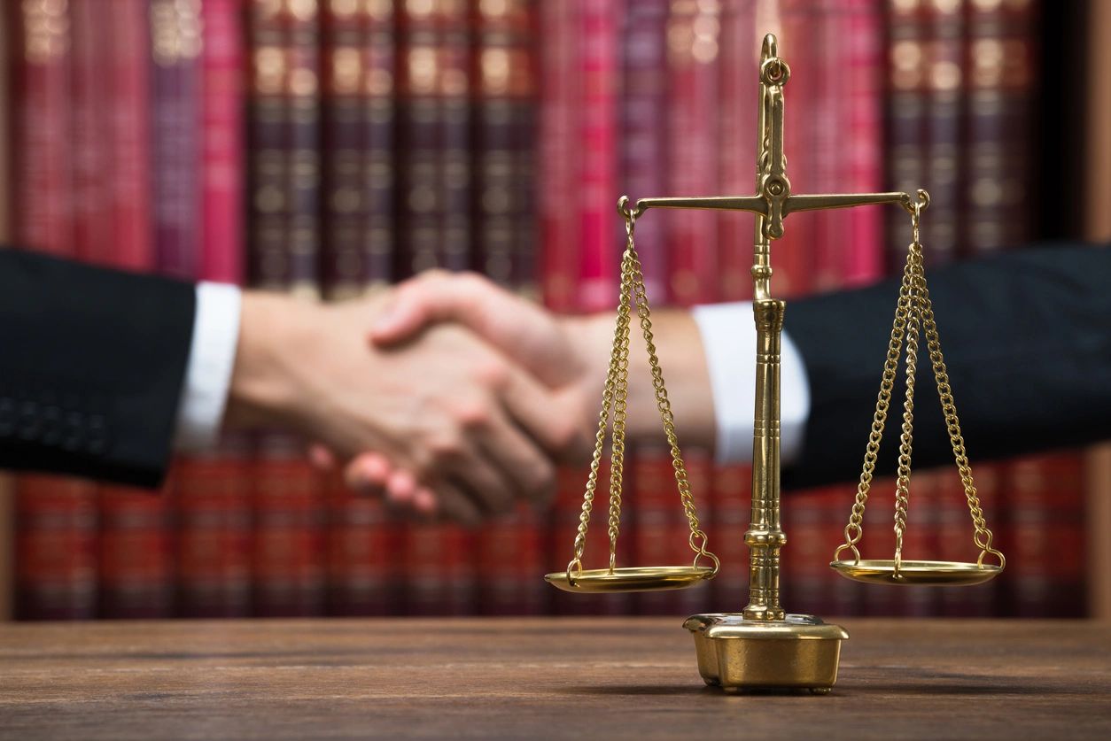 A judge 's desk with two people shaking hands.