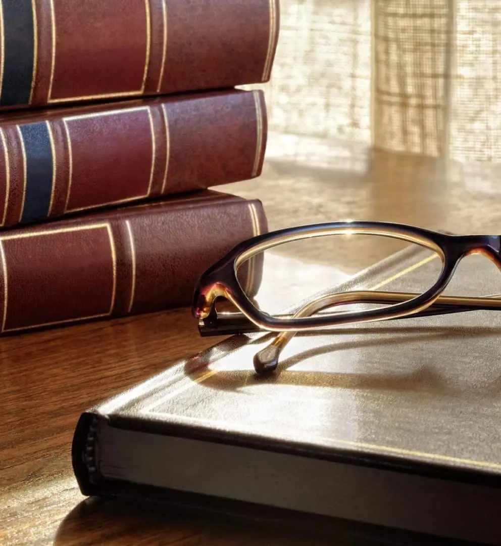 A pair of glasses sitting on top of an open book.